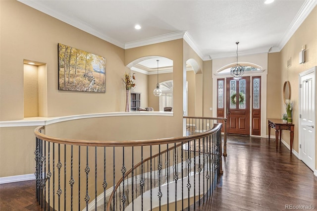 interior space with dark hardwood / wood-style flooring, crown molding, and an inviting chandelier