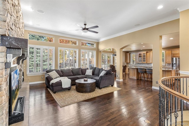 living room with dark hardwood / wood-style floors, ceiling fan, and crown molding