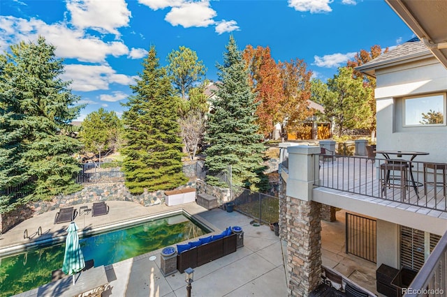 exterior space featuring a fenced in pool and a balcony