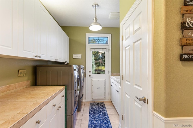 laundry room featuring cabinets and washing machine and clothes dryer