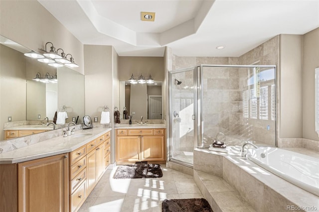 bathroom with tile patterned flooring, vanity, a raised ceiling, and shower with separate bathtub