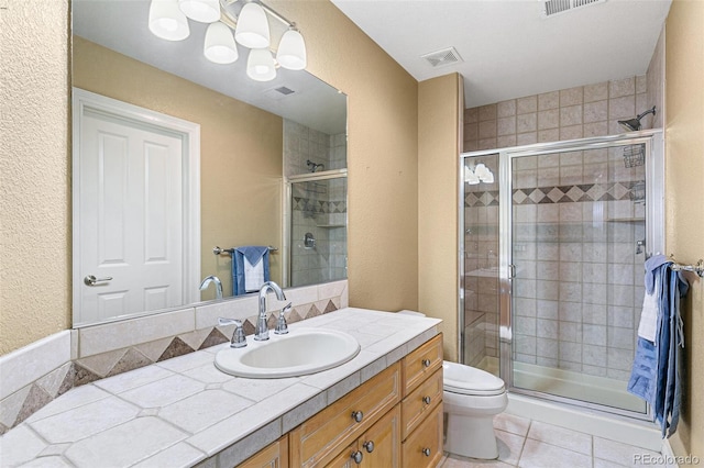 bathroom with tile patterned floors, vanity, toilet, and walk in shower