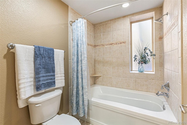 bathroom featuring shower / tub combo and toilet