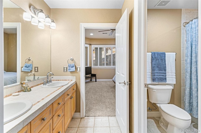 bathroom with toilet, vanity, tile patterned floors, and ceiling fan