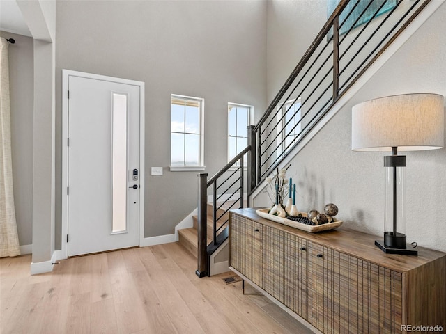 6244 N Lisbon St, Aurora, CO 80019 - entrance foyer featuring light wood-style floors, stairs, baseboards, and a high ceiling
