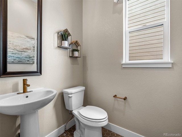 6244 N Lisbon St, Aurora, CO 80019 - half bathroom featuring baseboards, toilet, and a sink