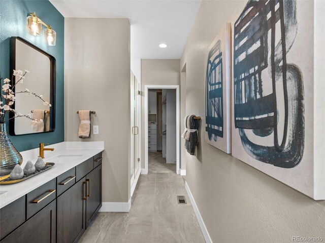 6244 N Lisbon St, Aurora, CO 80019 - bathroom featuring baseboards, vanity, and a walk in closet