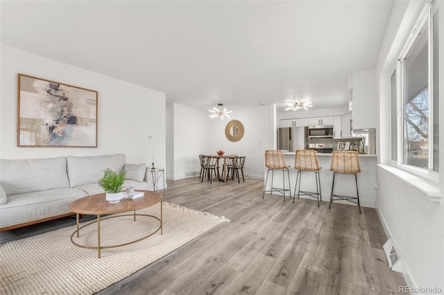 living room featuring ceiling fan and light hardwood / wood-style floors