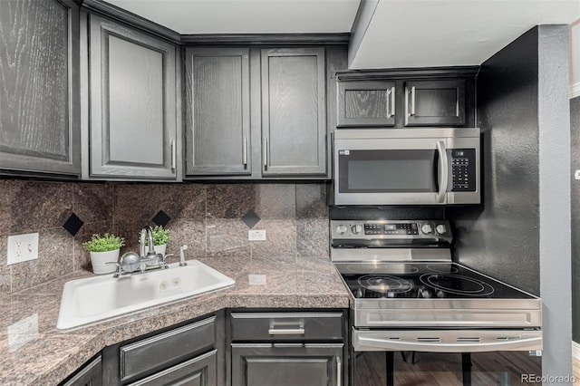 1390 N Emerson St Unit 101, Denver, CO 80218 - kitchen featuring stainless steel appliances, tile counters, gray cabinets, and tasteful backsplash