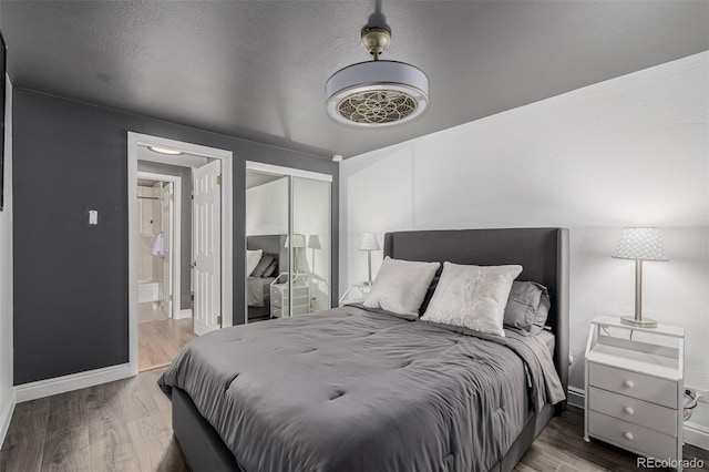 1390 N Emerson St Unit 101, Denver, CO 80218 - bedroom featuring wood finished floors, a closet, and connected bathroom