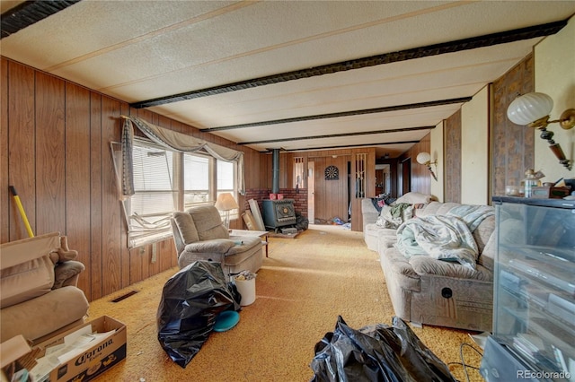 6224 County Road H, Joes, CO 80822 - carpeted living room featuring a wood stove, wood walls, and a textured ceiling