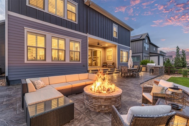 3256 Offbeaten Pl, Castle Rock, CO 80108 - rear view of property featuring board and batten siding, an outdoor living space with a fire pit, a patio, and outdoor dining area
