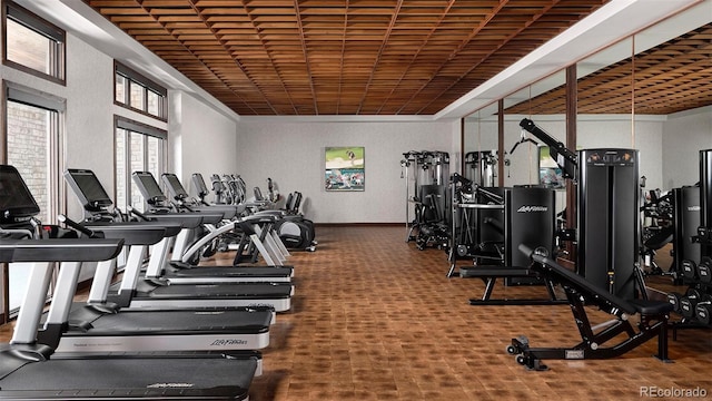 exercise room with wood ceiling and carpet flooring