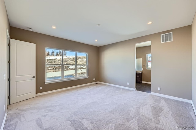 unfurnished room featuring light carpet and a wealth of natural light