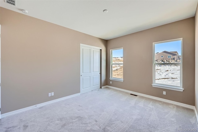 unfurnished bedroom with light colored carpet and a closet