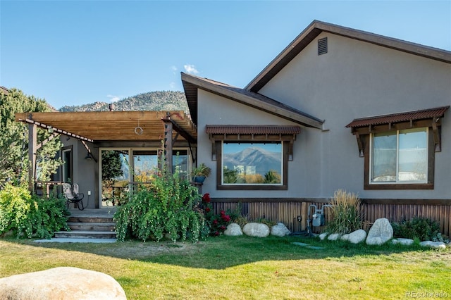 104 River Run Dr, Buena Vista, CO 81211 - back of property featuring a lawn, stucco siding, and a mountain view
