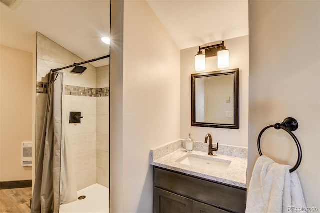 104 River Run Dr, Buena Vista, CO 81211 - bathroom with a tile shower, vanity, wood finished floors, heating unit, and vaulted ceiling