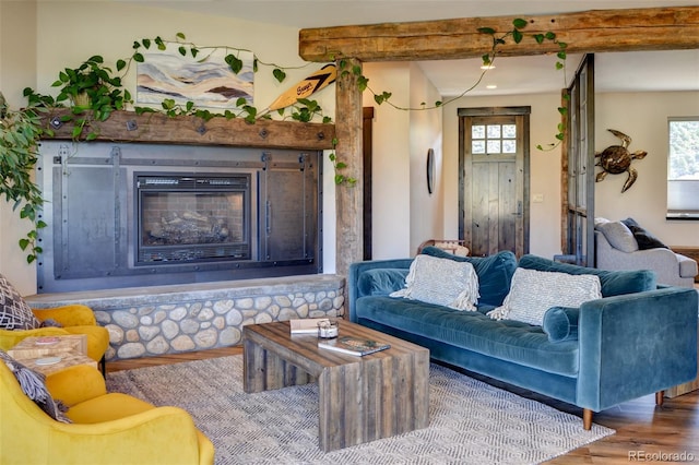 104 River Run Dr, Buena Vista, CO 81211 - living area with wood finished floors, a glass covered fireplace, and beamed ceiling