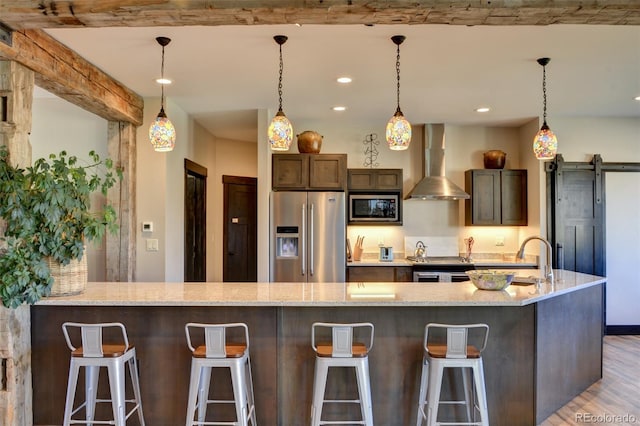 104 River Run Dr, Buena Vista, CO 81211 - kitchen featuring stainless steel appliances, wall chimney exhaust hood, light wood-style floors, light stone counters, and recessed lighting