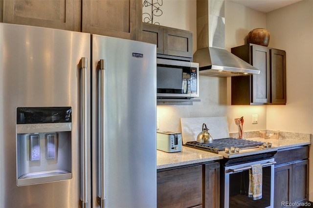 104 River Run Dr, Buena Vista, CO 81211 - kitchen with stainless steel appliances, wall chimney exhaust hood, light stone counters, and dark brown cabinetry