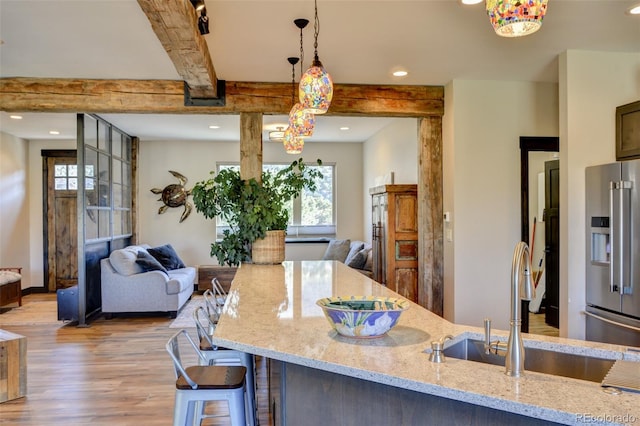 104 River Run Dr, Buena Vista, CO 81211 - kitchen with high quality fridge, light wood-type flooring, light stone countertops, decorative light fixtures, and open floor plan