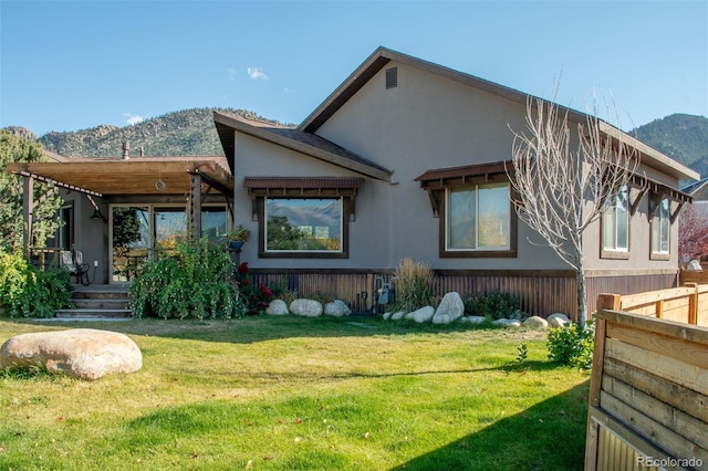 104 River Run Dr, Buena Vista, CO 81211 - back of property with a mountain view, a lawn, and stucco siding