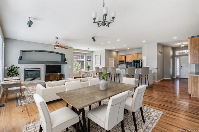 6085 Nile Cir, Golden, CO 80403 - dining area with a chandelier, light wood-type flooring, recessed lighting, a glass covered fireplace, and ceiling fan