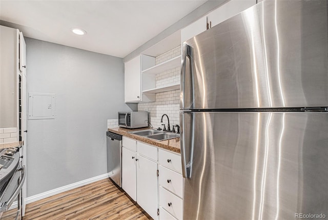 kitchen featuring open shelves, light wood-style floors, appliances with stainless steel finishes, white cabinetry, and tasteful backsplash