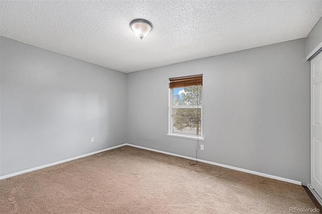 unfurnished room with baseboards, carpet floors, and a textured ceiling
