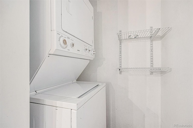 laundry room featuring stacked washer / drying machine and laundry area