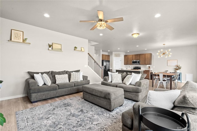 244 Chipeta Way, Lochbuie, CO 80603 - living room with light wood finished floors, ceiling fan, stairway, recessed lighting, and a chandelier
