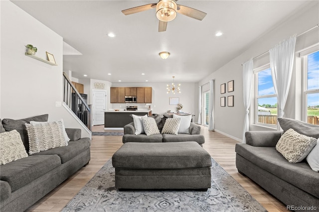 244 Chipeta Way, Lochbuie, CO 80603 - living room featuring a chandelier, light wood-style flooring, stairway, a ceiling fan, and recessed lighting