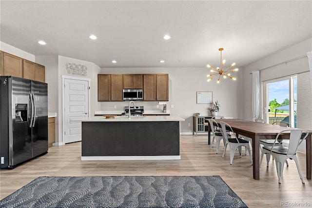 244 Chipeta Way, Lochbuie, CO 80603 - kitchen with appliances with stainless steel finishes, a chandelier, light countertops, recessed lighting, and light wood-style floors