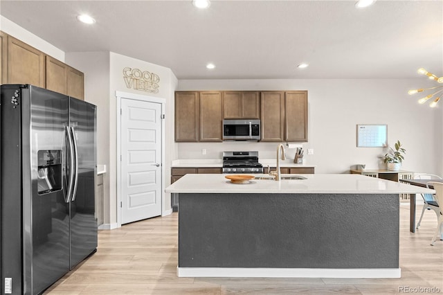 244 Chipeta Way, Lochbuie, CO 80603 - kitchen featuring stainless steel appliances, light wood-style floors, recessed lighting, light countertops, and an island with sink