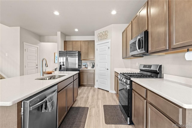 244 Chipeta Way, Lochbuie, CO 80603 - kitchen featuring stainless steel appliances, light wood-type flooring, light countertops, recessed lighting, and a center island with sink