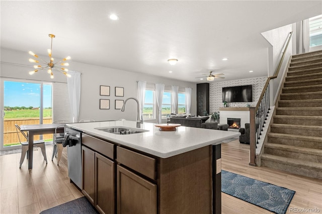 244 Chipeta Way, Lochbuie, CO 80603 - kitchen featuring a lit fireplace, dishwasher, light wood-style floors, light countertops, and recessed lighting