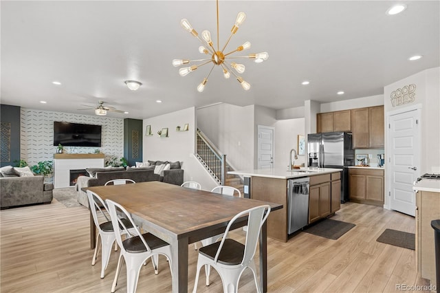 244 Chipeta Way, Lochbuie, CO 80603 - dining room with light wood-type flooring, recessed lighting, ceiling fan, a fireplace, and stairway