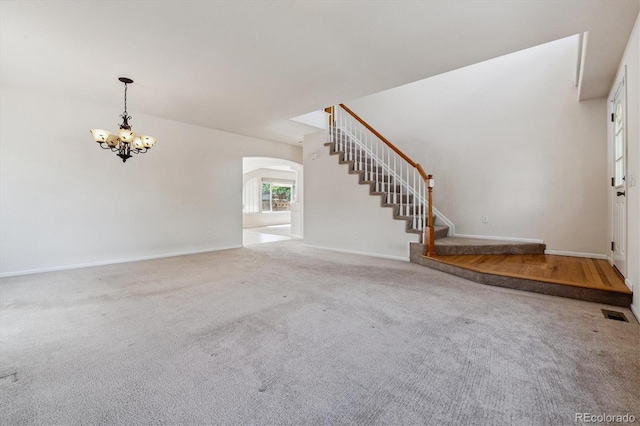4848 Fenwood Dr, Highlands Ranch, CO 80130 - unfurnished living room featuring arched walkways, a chandelier, stairs, and carpet flooring