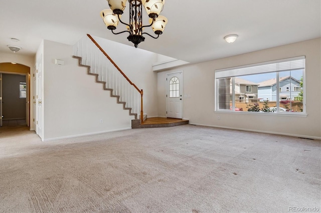 4848 Fenwood Dr, Highlands Ranch, CO 80130 - foyer entrance featuring a chandelier, carpet, arched walkways, and stairs