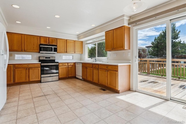 4848 Fenwood Dr, Highlands Ranch, CO 80130 - kitchen with appliances with stainless steel finishes, light countertops, brown cabinets, recessed lighting, and ornamental molding