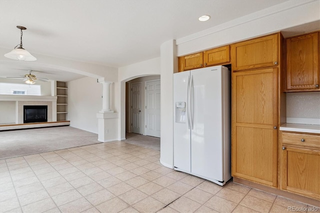 4848 Fenwood Dr, Highlands Ranch, CO 80130 - kitchen with white fridge with ice dispenser, arched walkways, a ceiling fan, light colored carpet, and a fireplace
