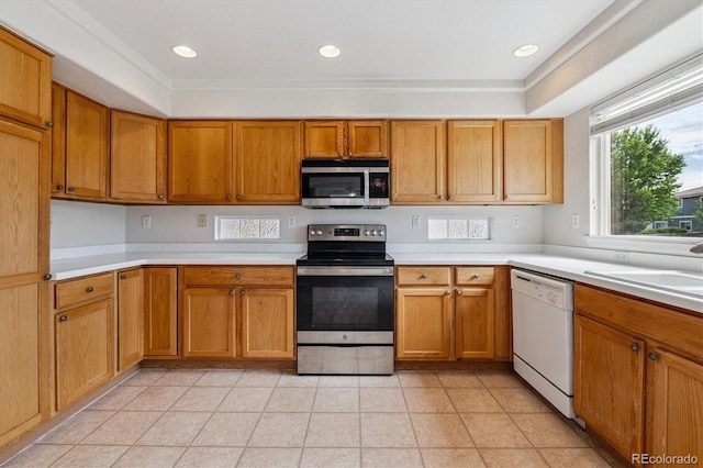 4848 Fenwood Dr, Highlands Ranch, CO 80130 - kitchen featuring appliances with stainless steel finishes, light countertops, brown cabinets, light tile patterned floors, and recessed lighting