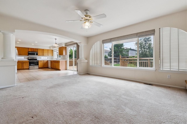 4848 Fenwood Dr, Highlands Ranch, CO 80130 - unfurnished living room with ornate columns, light carpet, a ceiling fan, arched walkways, and recessed lighting