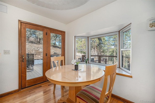 dining area with plenty of natural light, light wood-style flooring, and baseboards