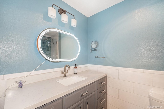 bathroom with vanity and tile walls