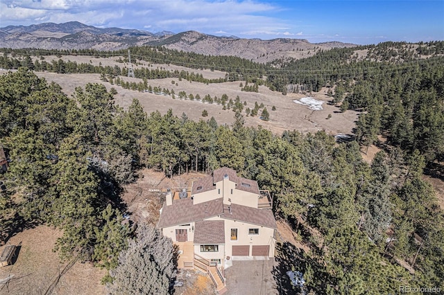 aerial view featuring a forest view and a mountain view