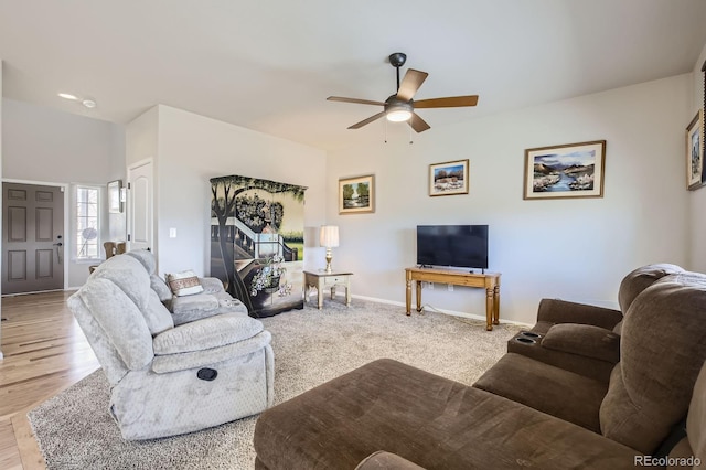 living room featuring a ceiling fan and baseboards