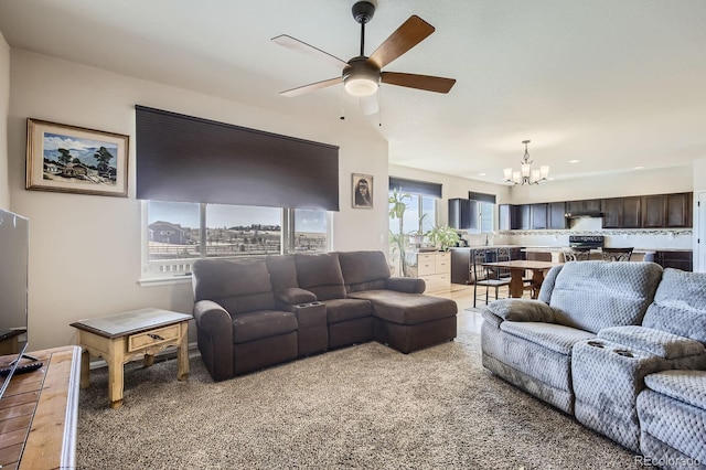 living area with ceiling fan with notable chandelier