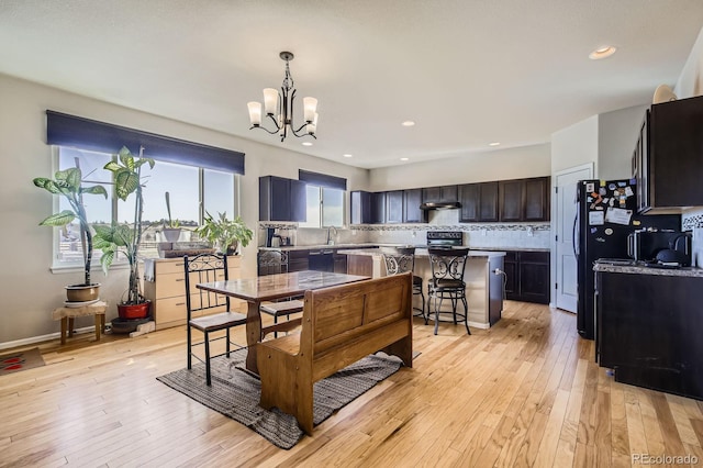 dining area featuring a chandelier, light wood-type flooring, baseboards, and recessed lighting