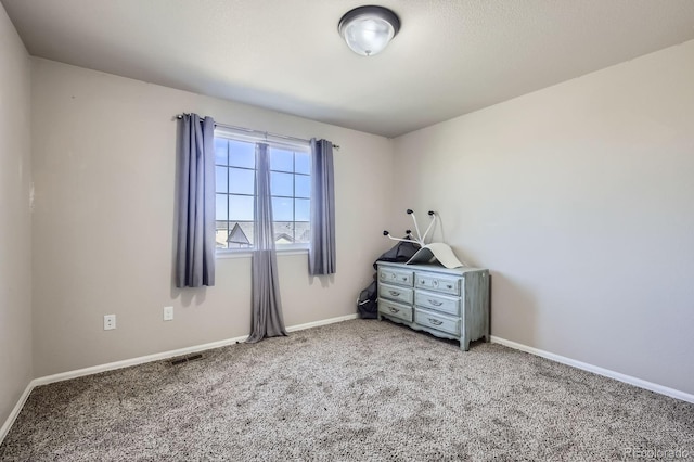 unfurnished bedroom featuring carpet floors, visible vents, and baseboards